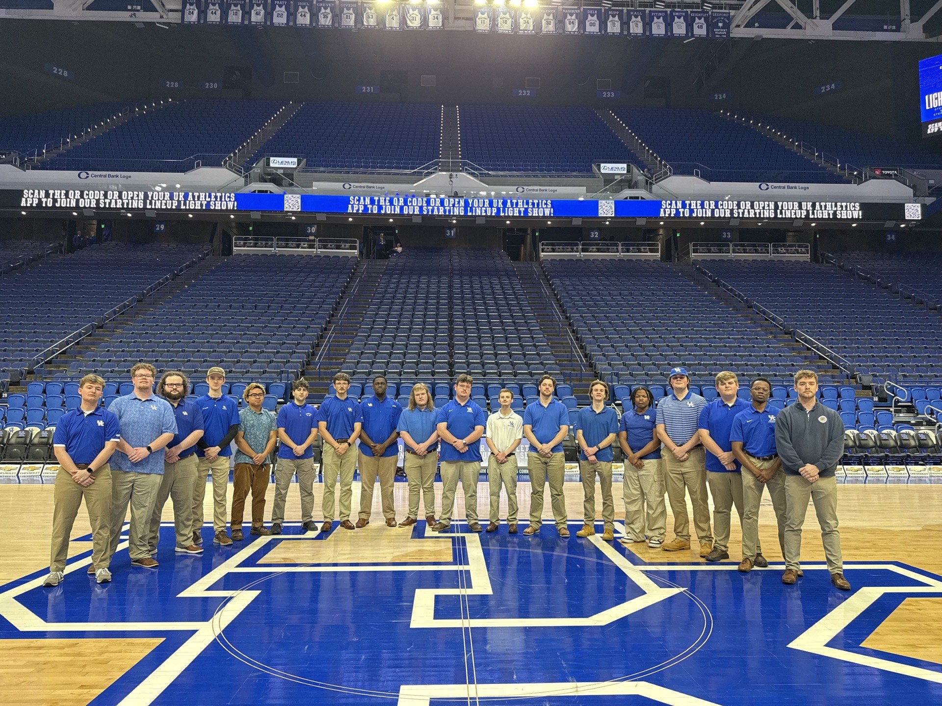 The acoUstiKats standing together on the basketball court at Rupp Arena.